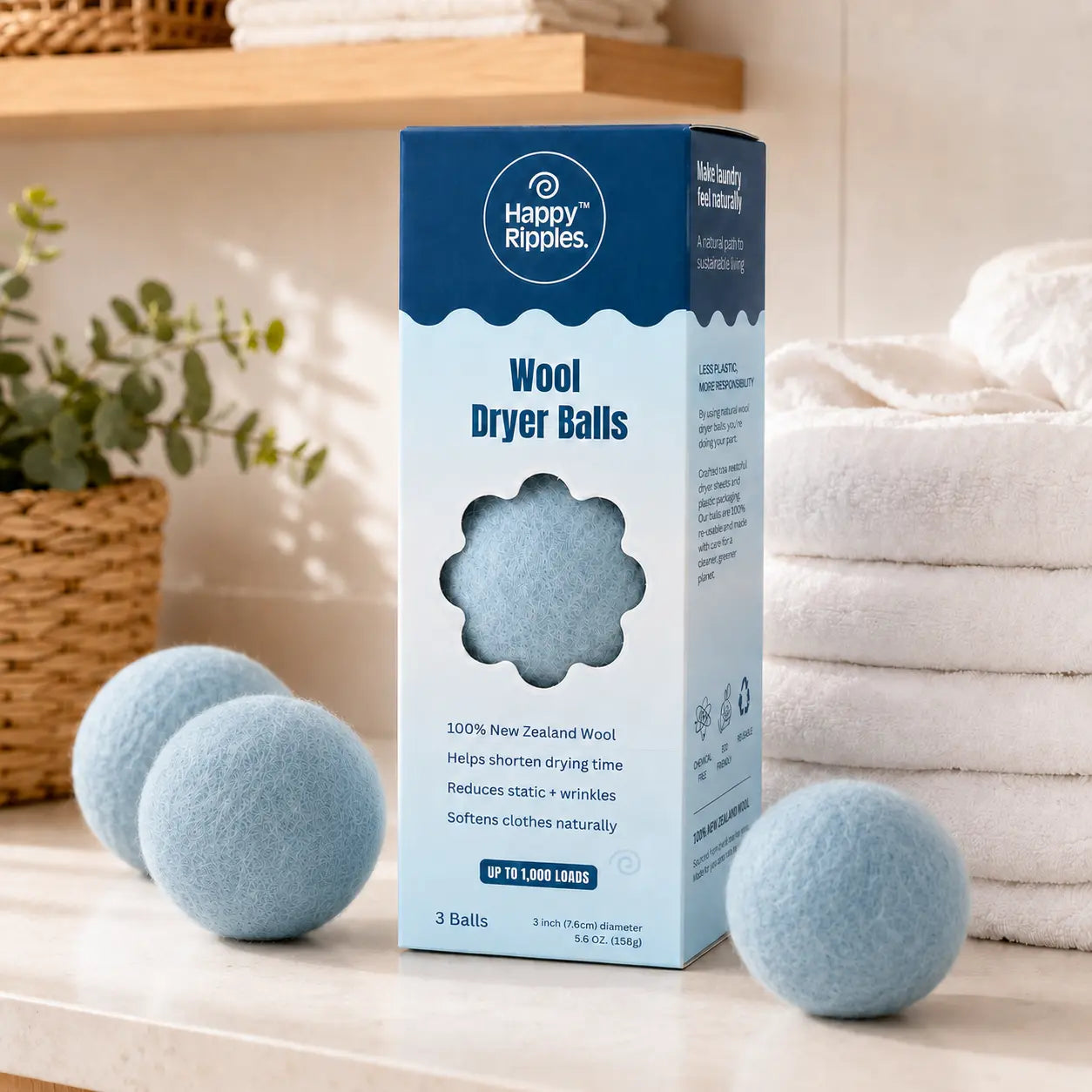 Happy Ripples blue wool dryer balls beside folded towels in a bright laundry room.