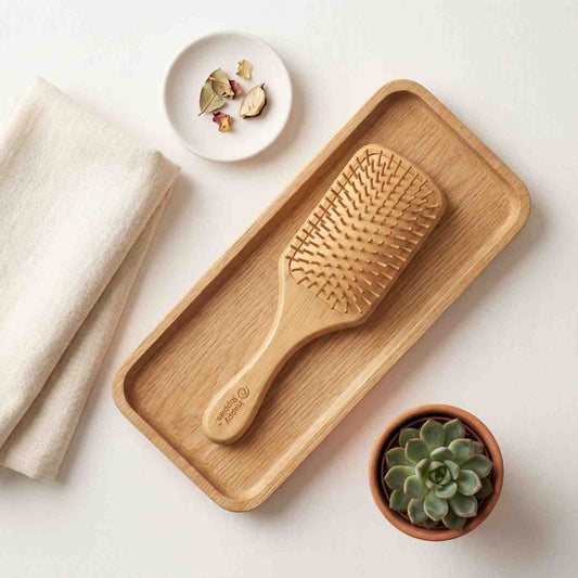 Happy Ripples bamboo paddle hairbrush displayed on a wooden tray with natural home decor and clean self care styling