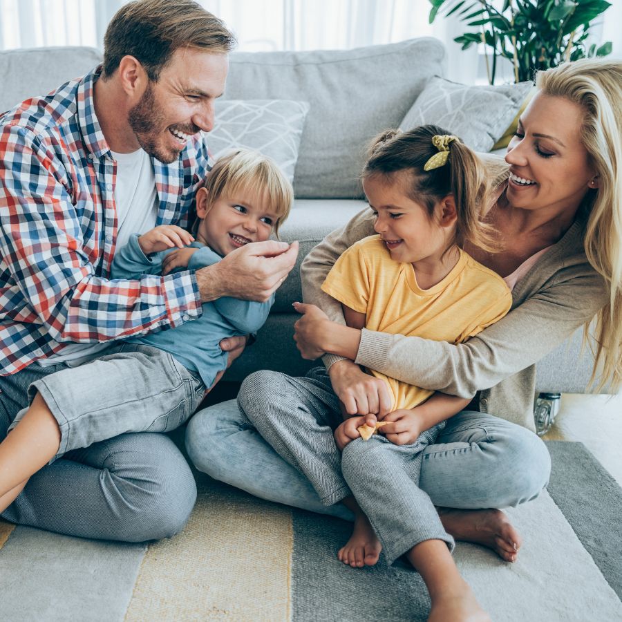 Smiling family relaxing together at home representing Happy Ripples gentle laundry care for everyday clean routines