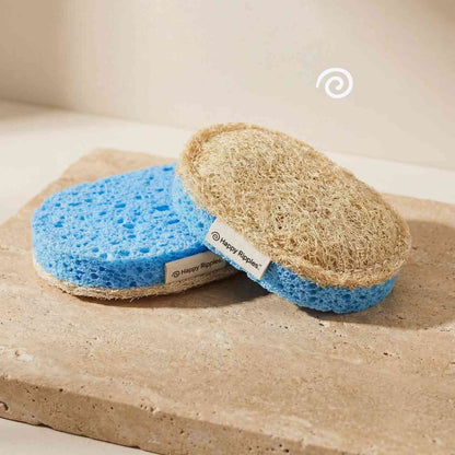 Happy Ripples loofah sponge with blue scrub layer on stone surface.
