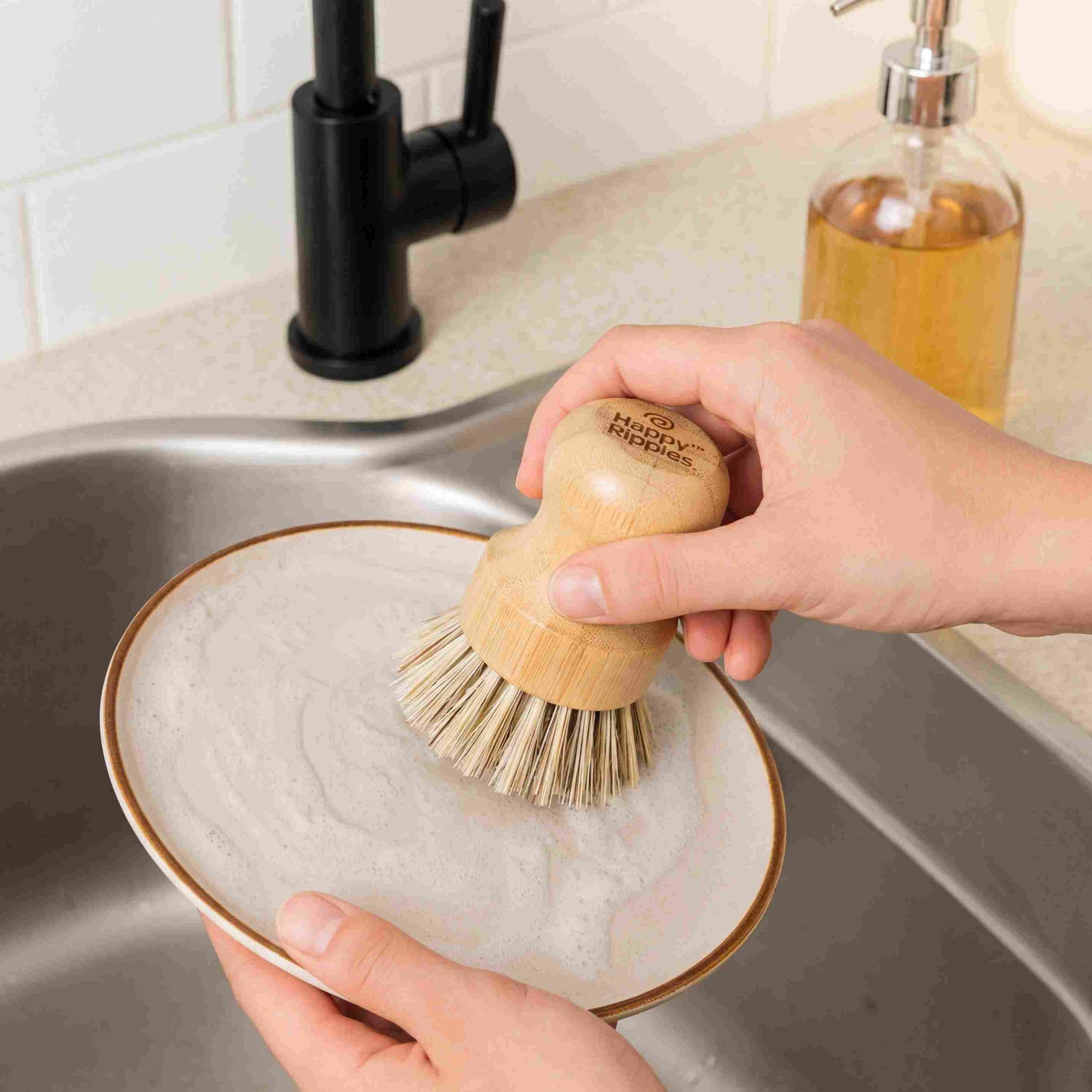 A natural wooden dish brush held under running water