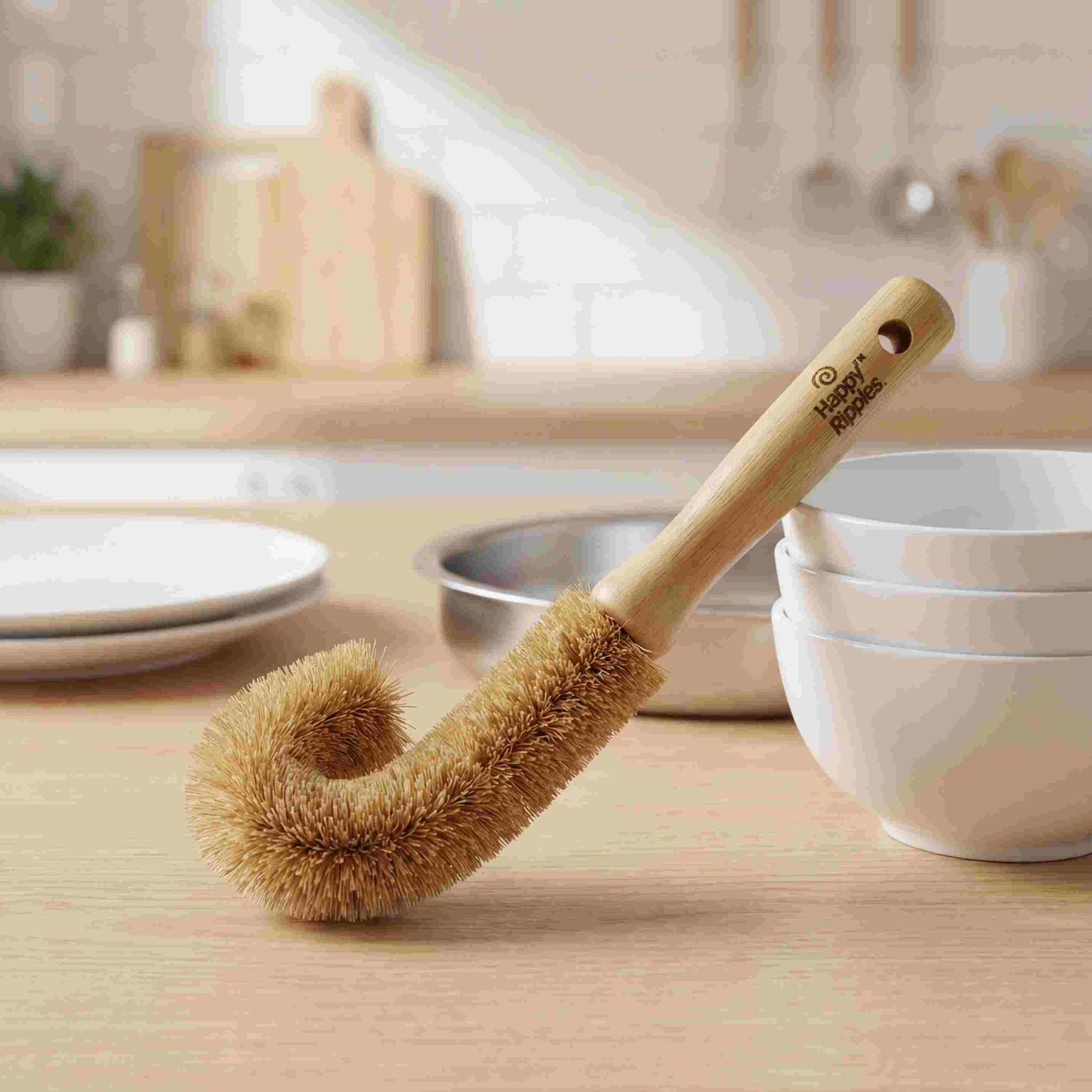 A wooden dish brush styled on a soft pink background